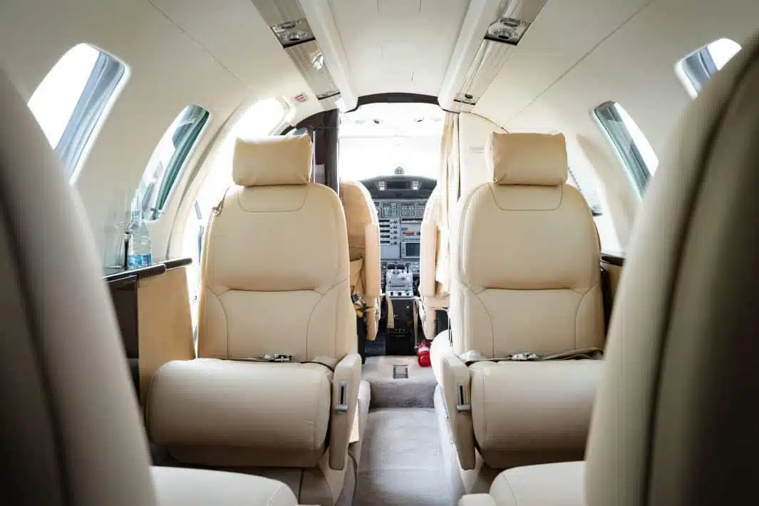 the inside of a private airplane in a white and black finish and beige seats
