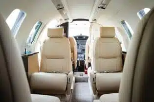 the inside of a private airplane in a white and black finish and beige seats