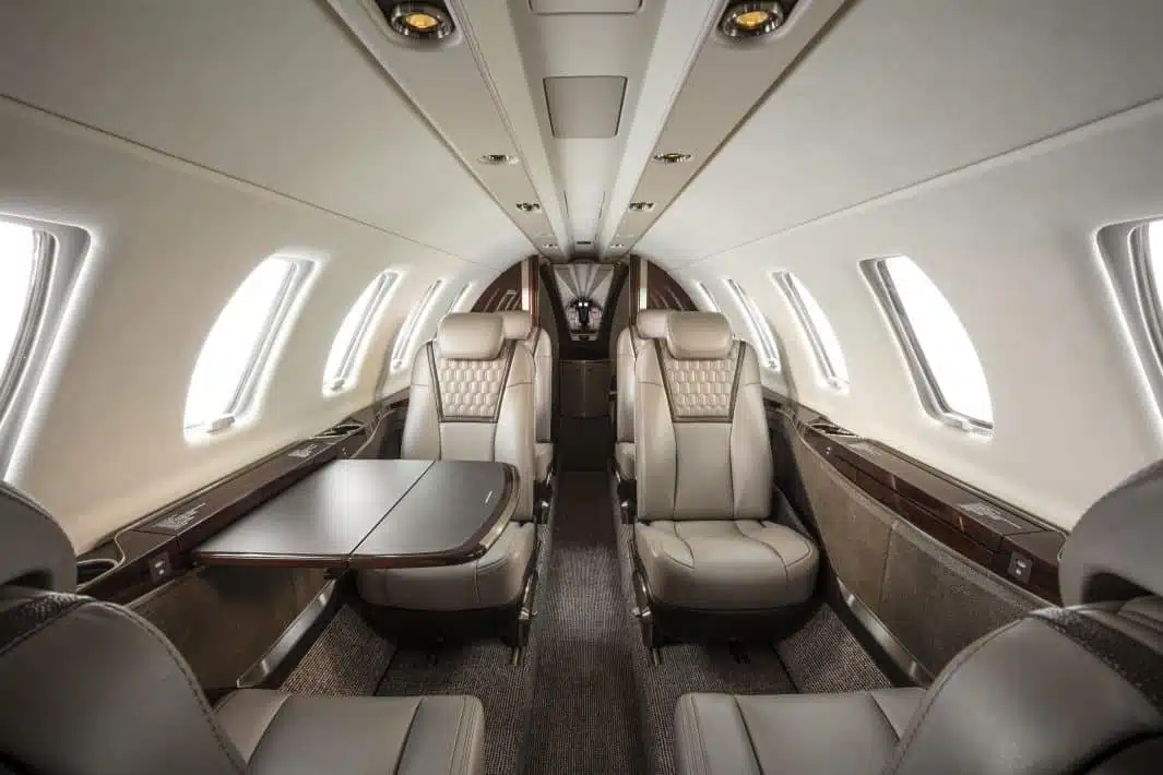 the inside of a private airplane with a white and brown finish and brown leather seats