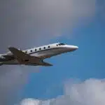 private airplane flying below clouds