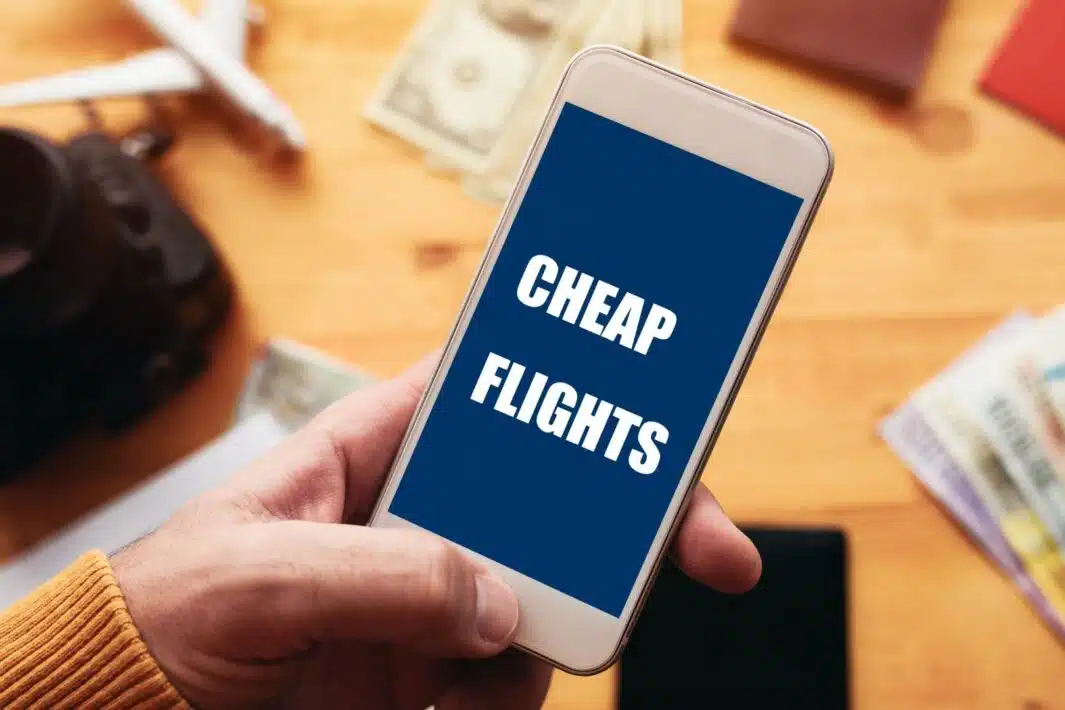 Mobile phone displaying "Cheap Flights" highlighting the accessibility of affordable private jet booking. Start your search for cheap private jet travel today.