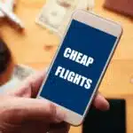 Mobile phone displaying "Cheap Flights" highlighting the accessibility of affordable private jet booking. Start your search for cheap private jet travel today.