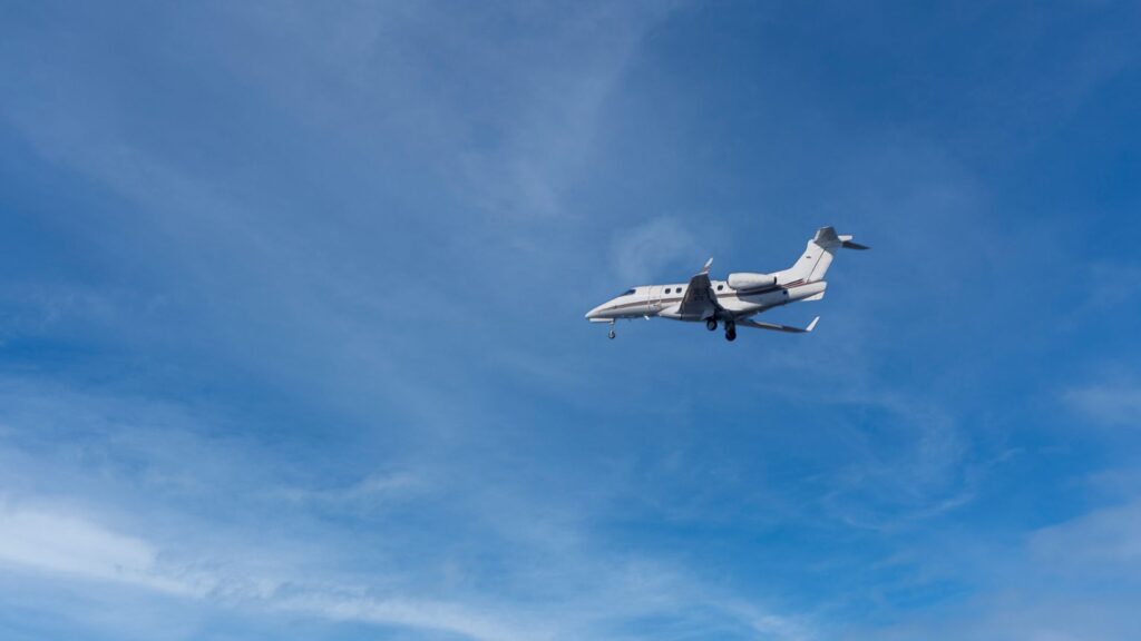 a well-composed and visually appealing shot of a white private jet in flight with a clear blue sky in the background