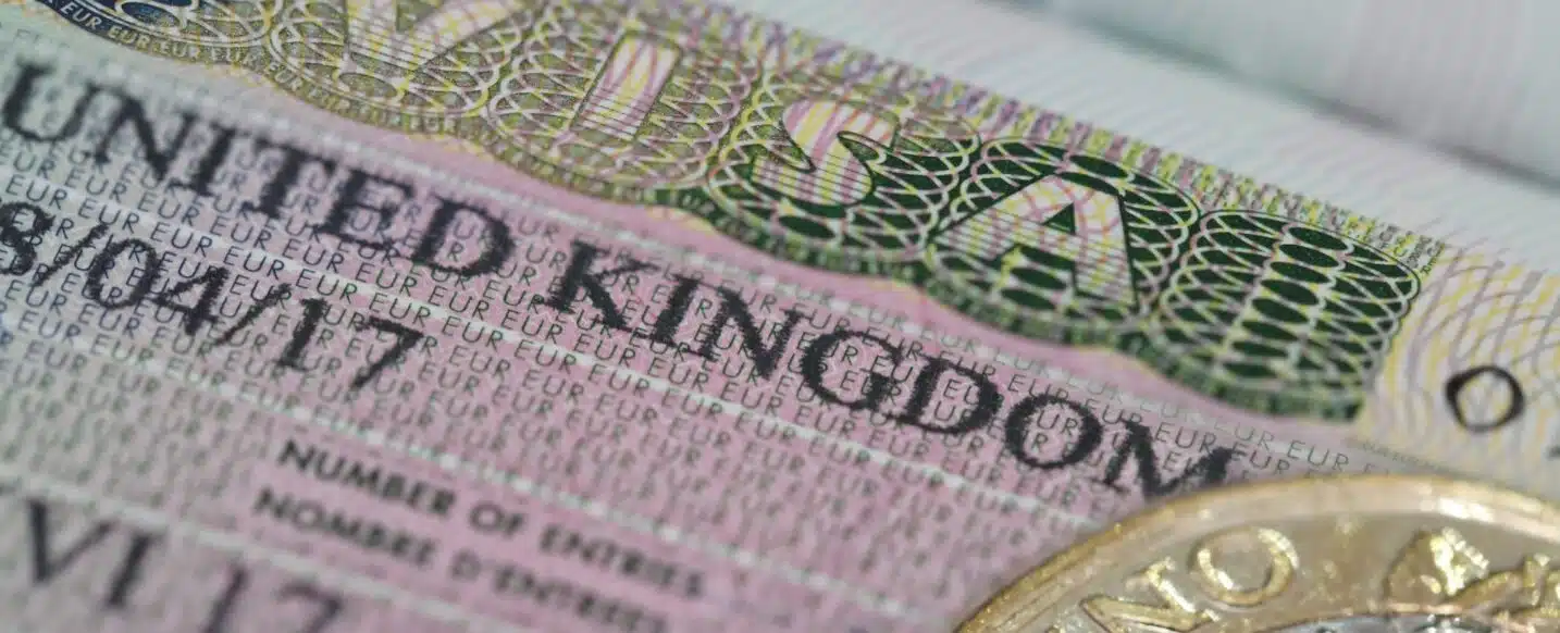 United Kingdom visa in the passport with one pounds coin