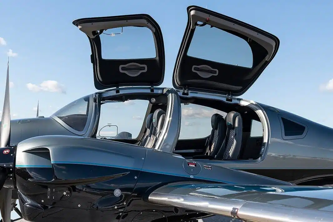 exterior close-up picture of a diamond da62 aircraft with business seating configuration and two open doors. the sky is clear with a few visible clouds.