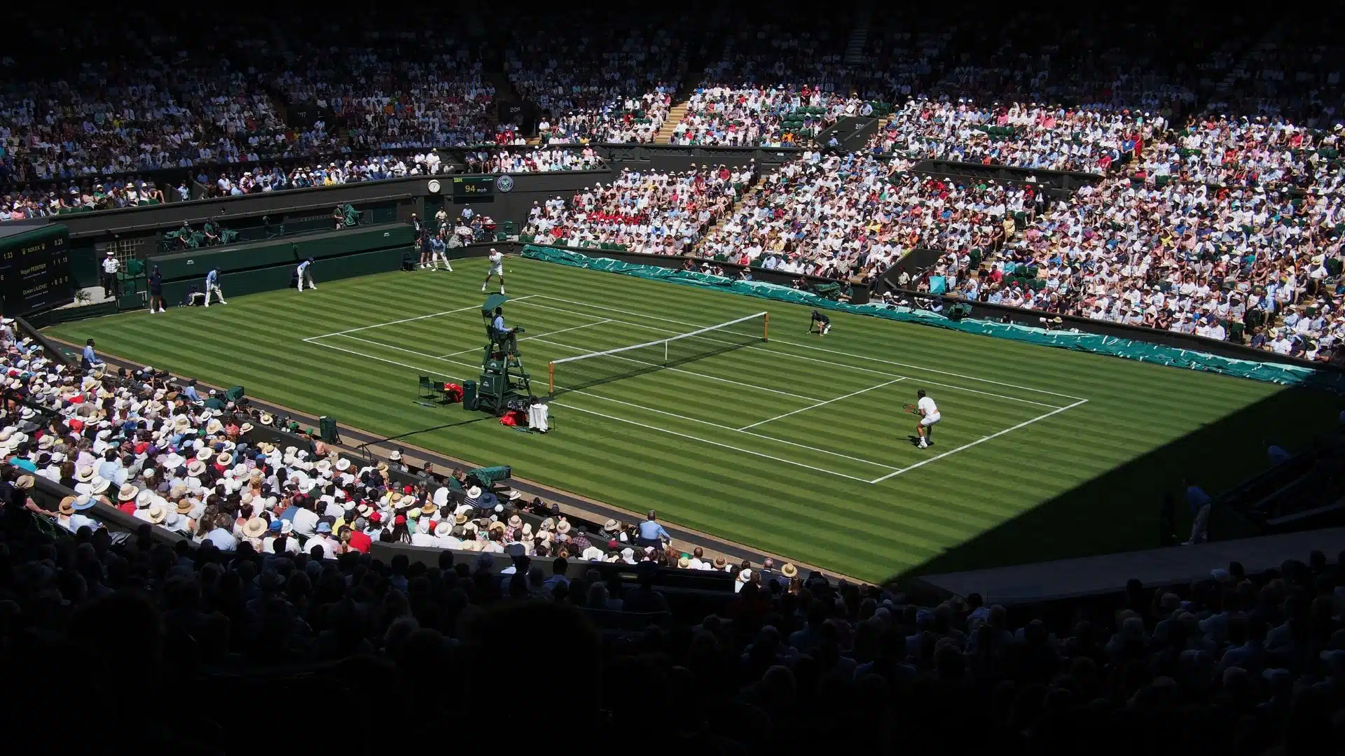 Two person playing tennis. Roger Federer’s opening match in the 2018 Championships at Wimbledon against Dusan Lajovic of Serbia.