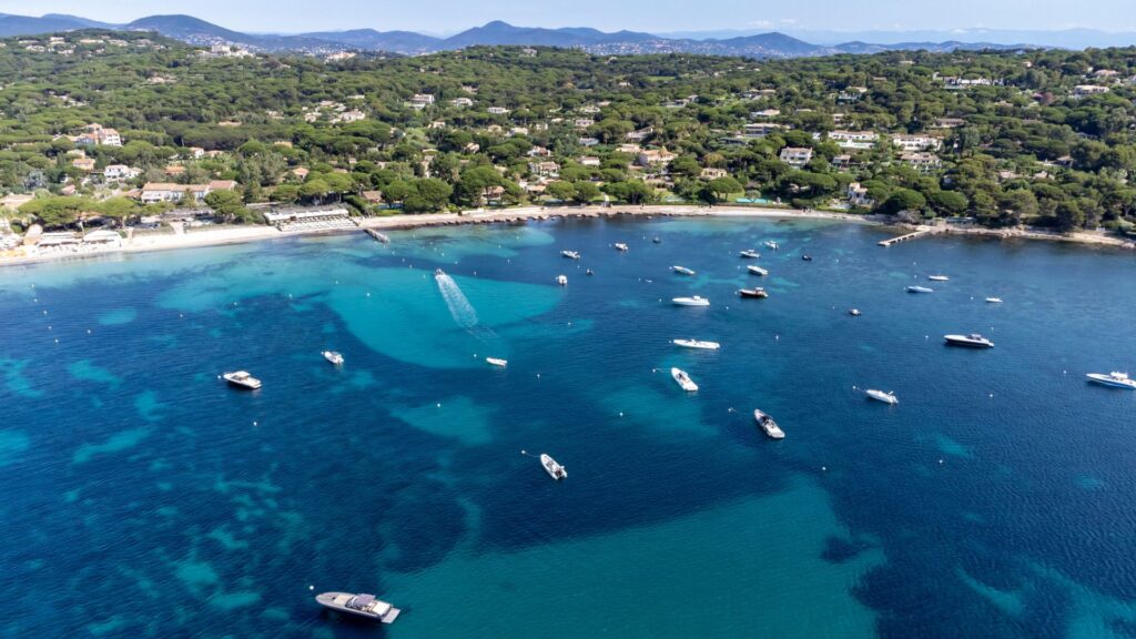 Crystal clear blue water of legendary Pampelonne beach near Saint-Tropez, summer vacation on white sandy beach of French Riviera, France