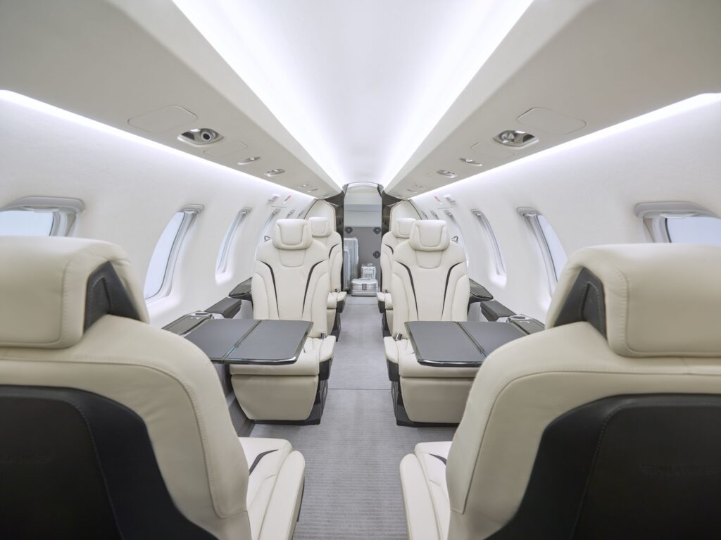 Front view of a Pilatus PC-24 interior featuring white leather seating.